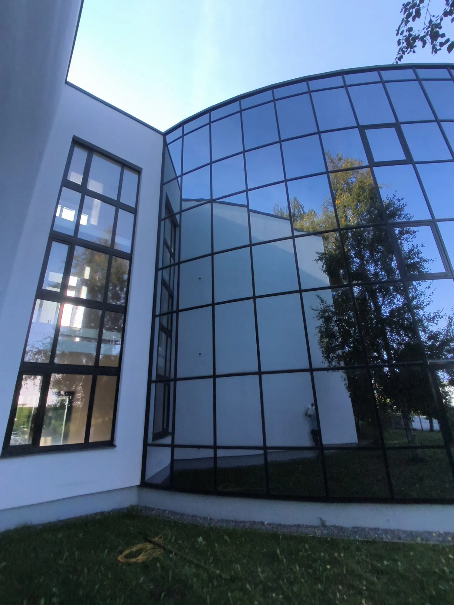 Ümara klaasfassaadi nurk peale välispesu, peegeldav puhas klaas