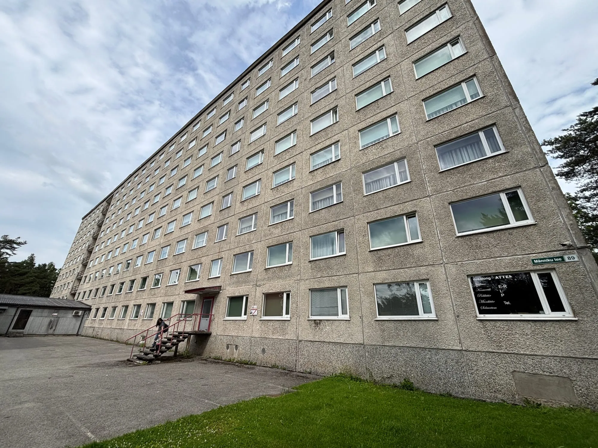 Pikk paneelfassaad aadressisildiga — kõrghoone akende välipesu objekt