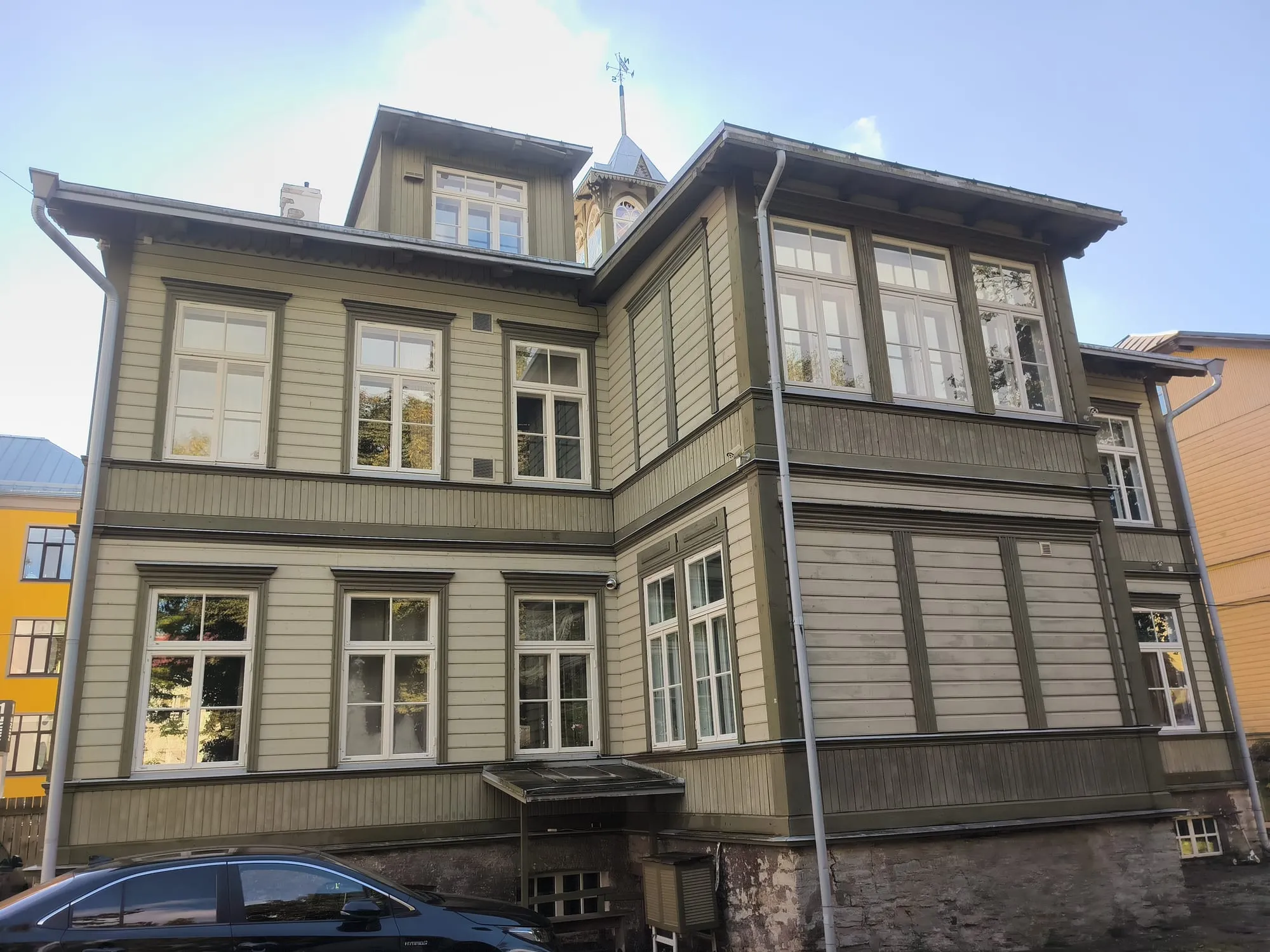 Ajaloolise puitmaja nurgavaade klaasveranda ja torniga, aknad puhtaks pestud