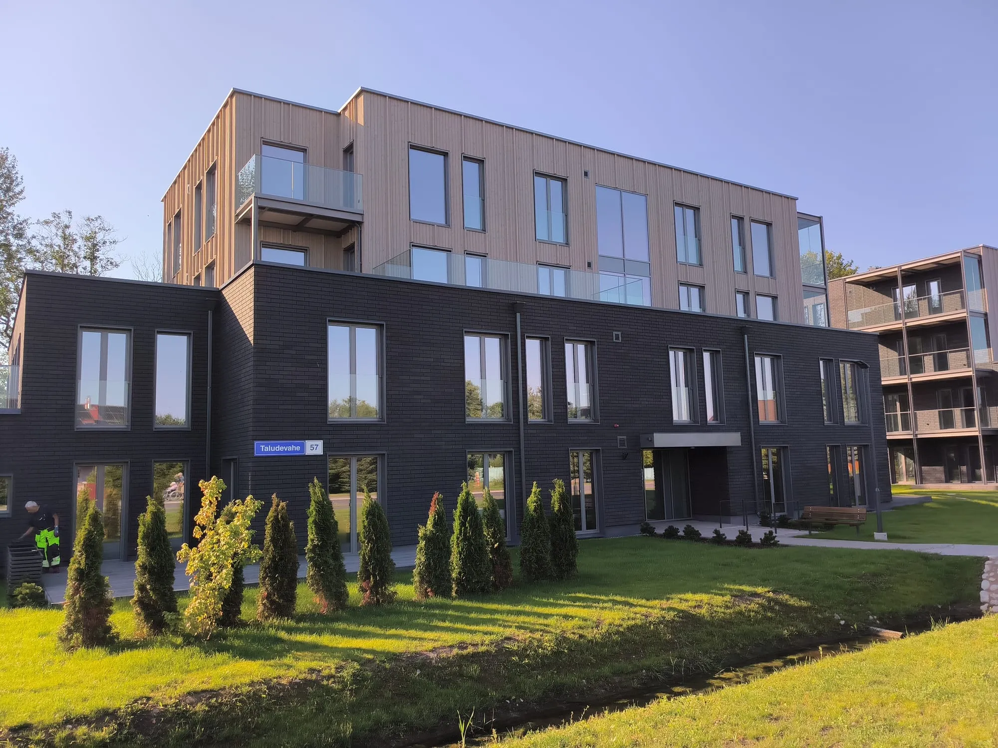 Korterelamu välisvaade puhaste akendega, ees tööd tegev tehnik