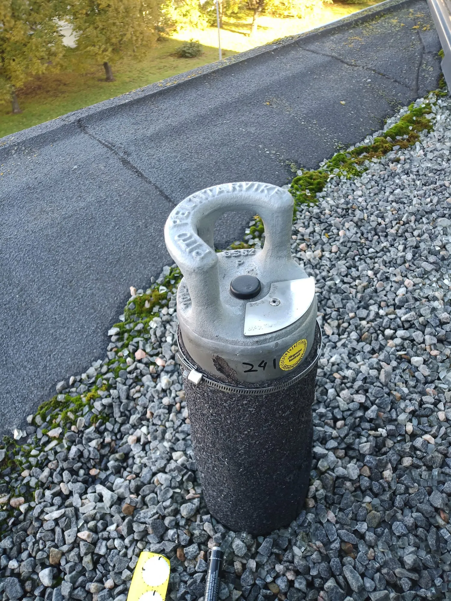 Kukkumiskaitse ankrupunkt hoone lamekatusel, taustal haljastus