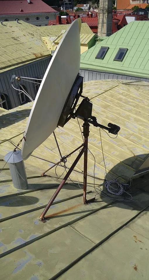 Satelliitantenn kolme jalaga raamil kollasel plekk-katusel enne demontaaži