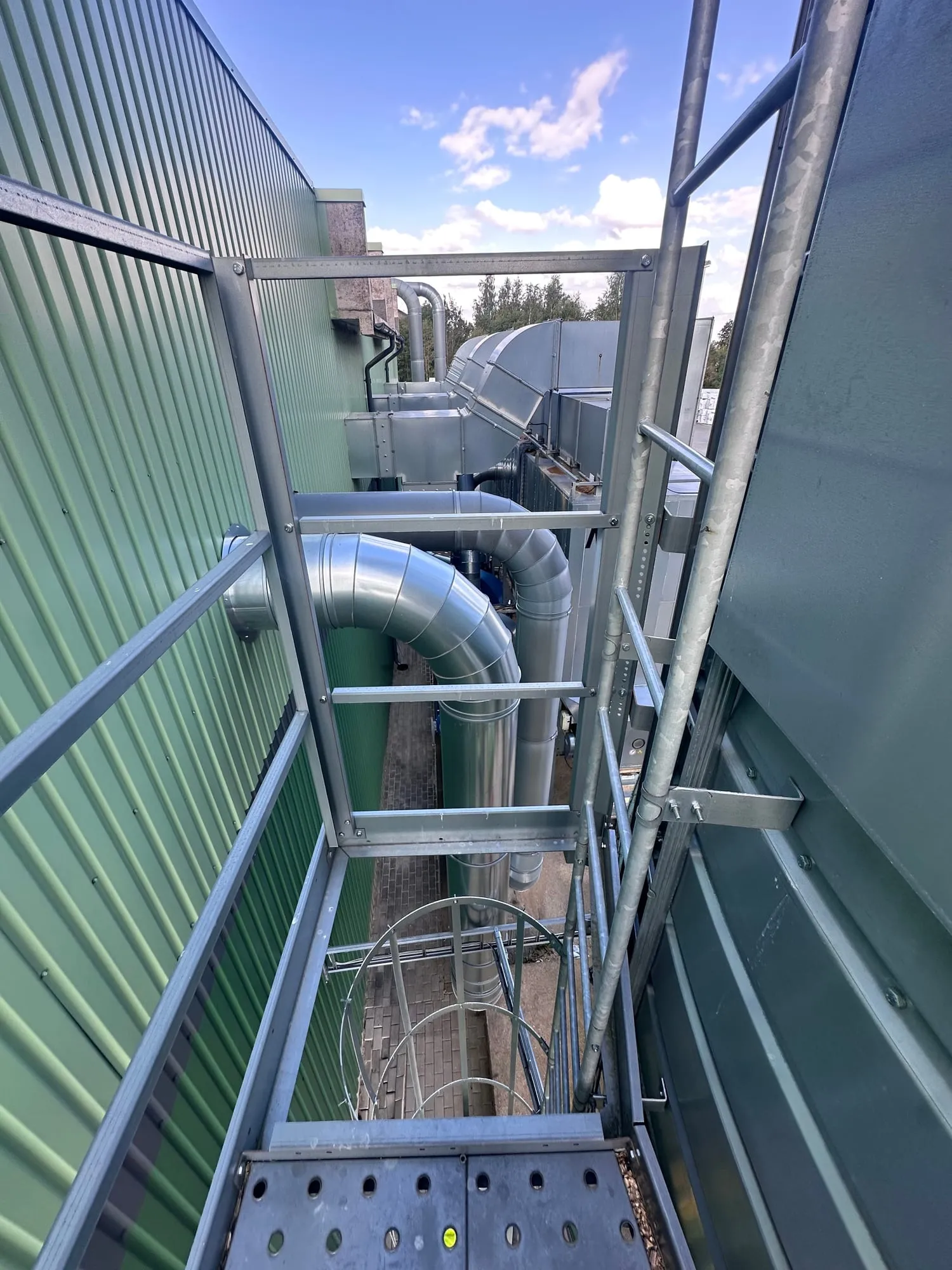 Katusel kulgev terasplatvorm käsipuudega ja ventilatsioonitorustik tööstushoone katusel