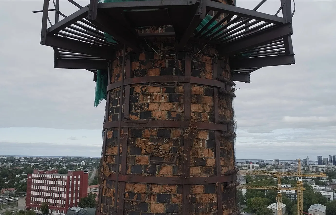 Korstna ülaosa metallvöödega ja töörõduga, taustal Tallinna panoraam