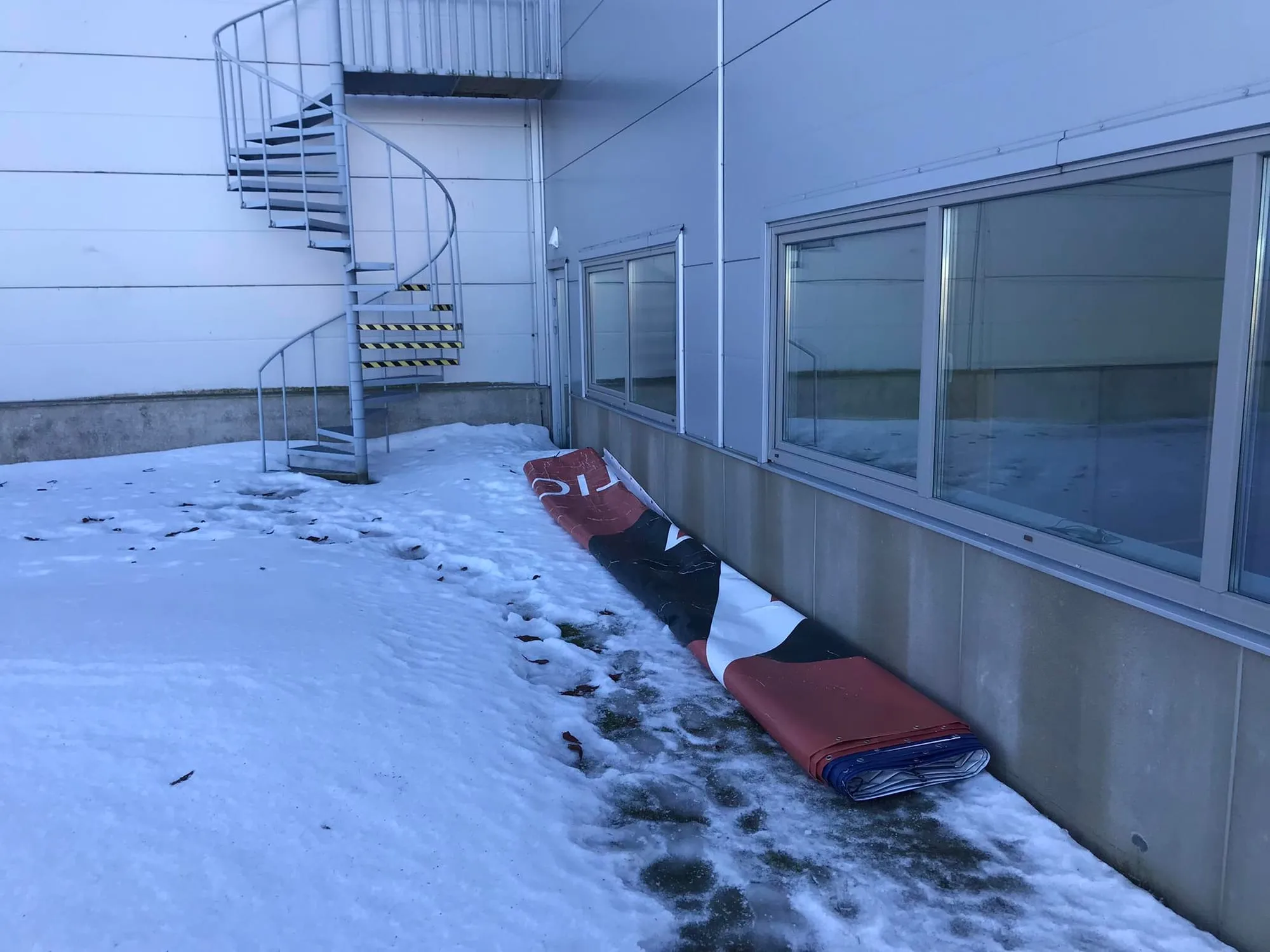 Kokku rullitud reklaambänner tootmishoone õuel pärast eemaldamist kõrguselt