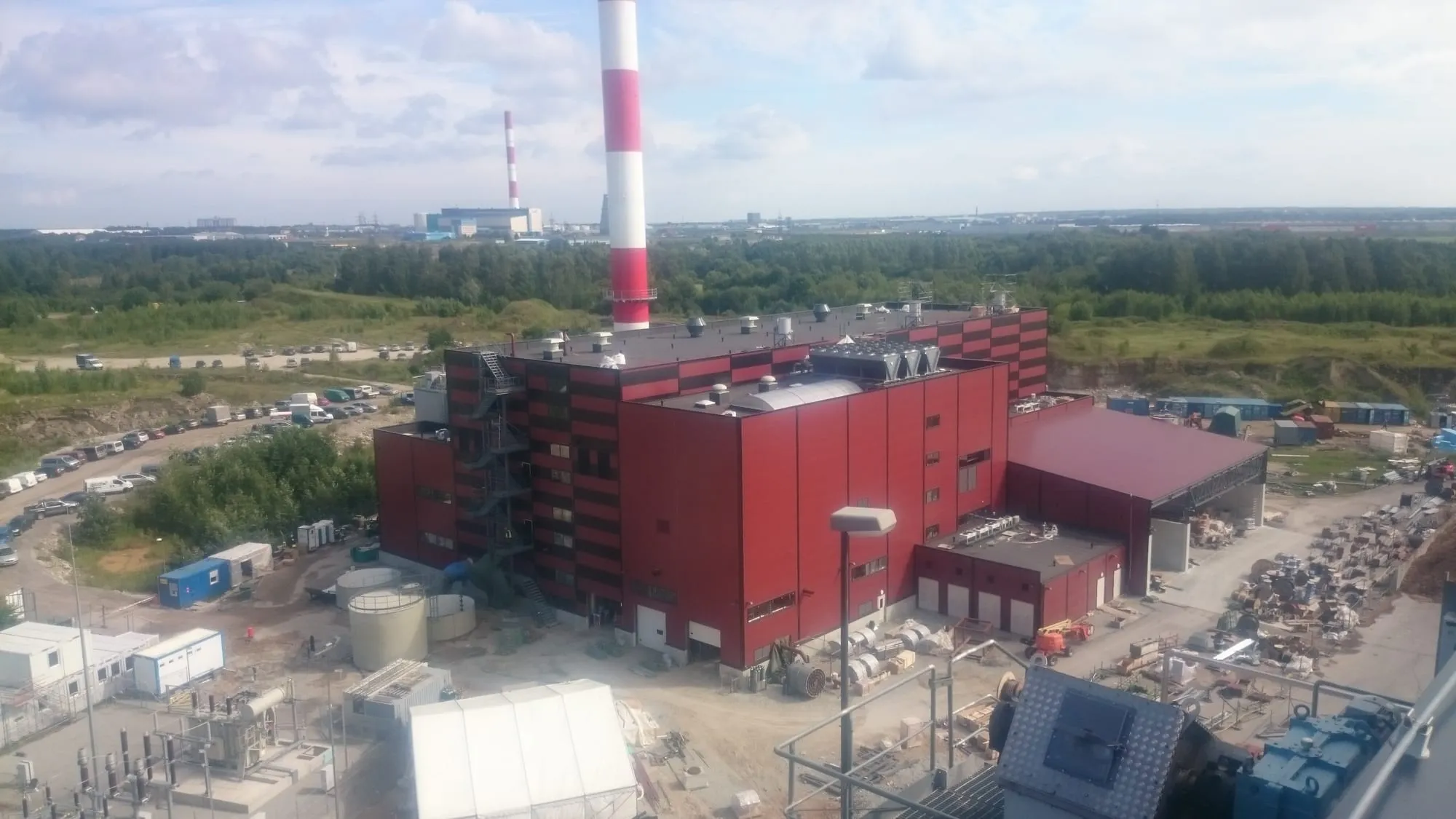 Punase fassaadiga tööstushoone Väos ülalt vaadatuna, taustal punavalged korstnad ja parkla.