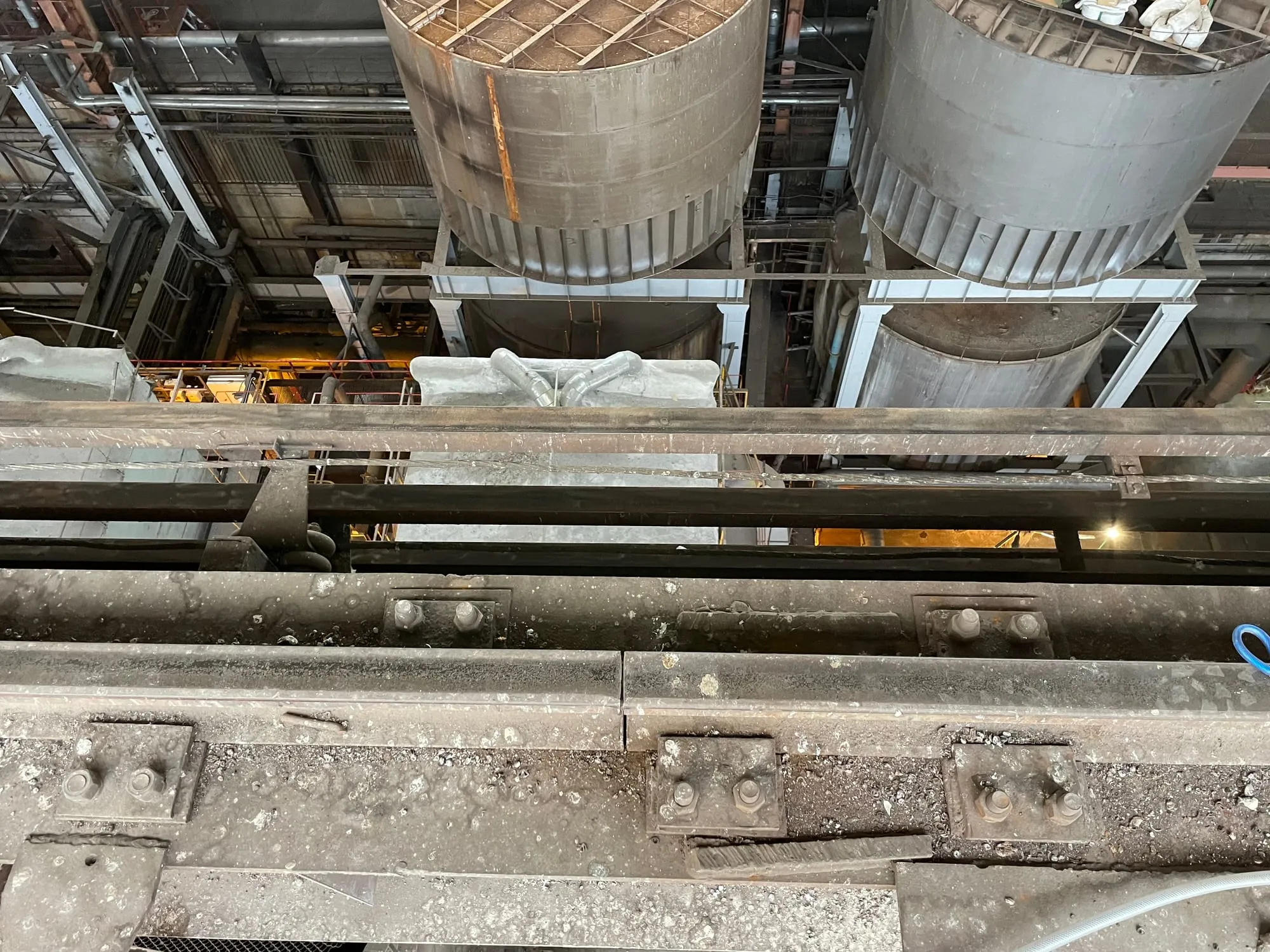 Sildkraana paksu mustusekihiga kaetud käigutee, all suured metallmahutid elektrijaama katlamajas