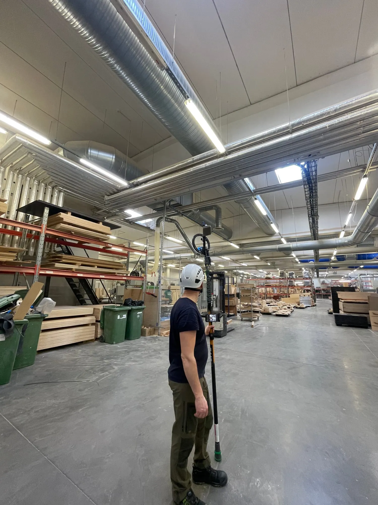Tehnik suunab kaameraga teleskoopvarda puidutöötlusala lae ventilatsioonitorude poole tolmuauditil