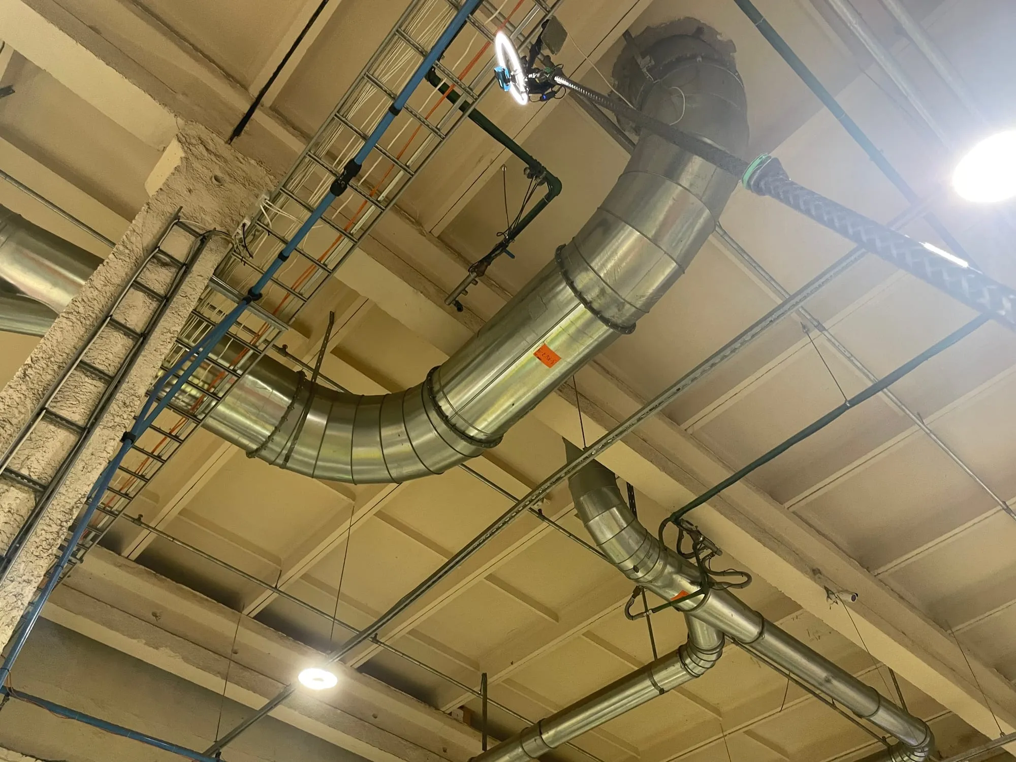 Teleskoopvarras küünib tootmishoone suurte ventilatsioonitorudeni tolmu eemaldamiseks