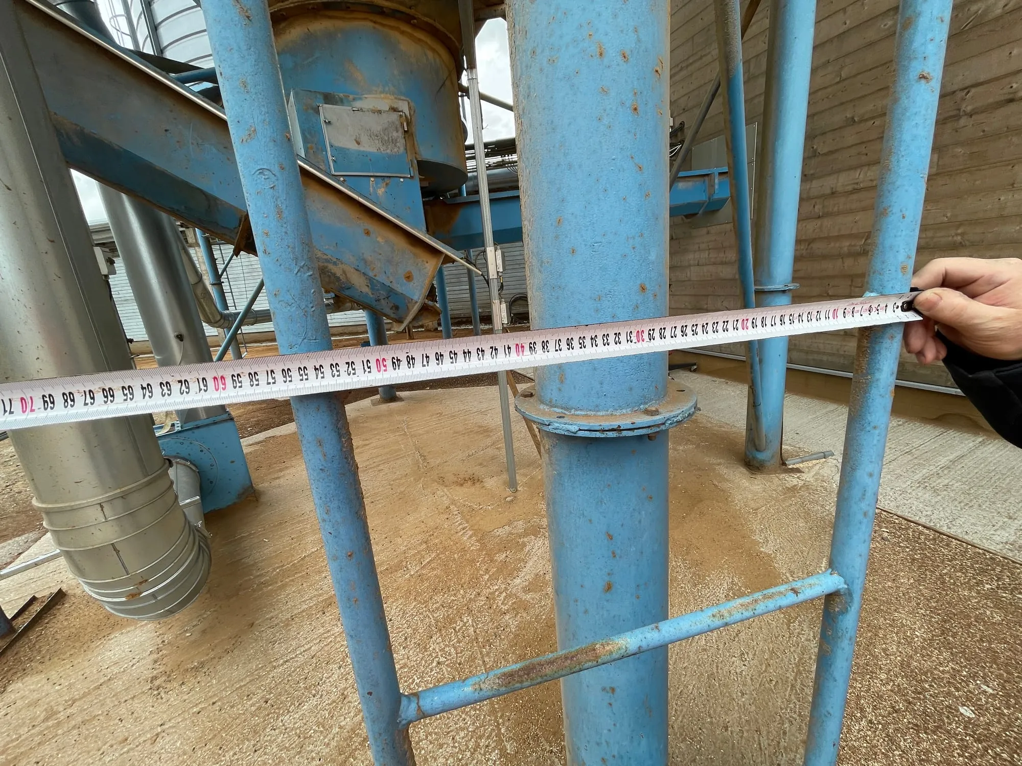 Tehnik mõõdistab silo redeli mõõtusid enne kukkumiskaitse siini paigaldust